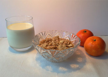 Vaso de leche, cereales y mandarinas